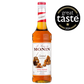 A 0.7L bottle of MONIN Caramel Syrup is displayed. The label reads "Le Sirop de MONIN" and "Caramel" with an image of caramel pieces and caramel sauce, making it a perfect addition to coffee or chocolate. The amber-colored liquid inside the bottle has "Arômes Naturels" and "Product of France" written on the label.